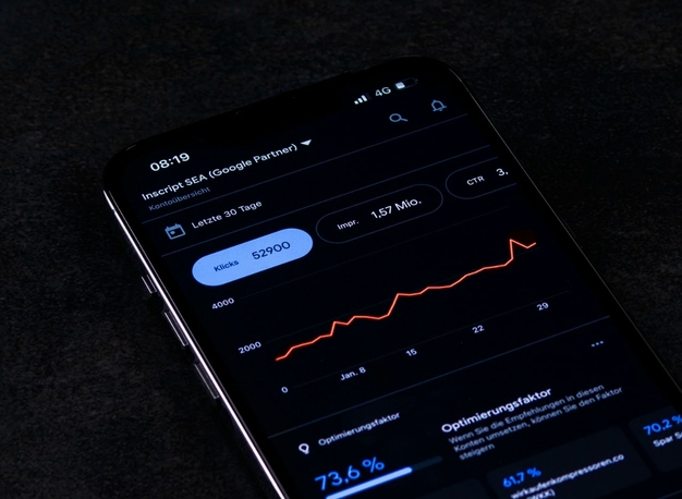 Ein Smartphone, das Börsendaten mit einer steigenden Trendlinie auf dem Bildschirm anzeigt.
